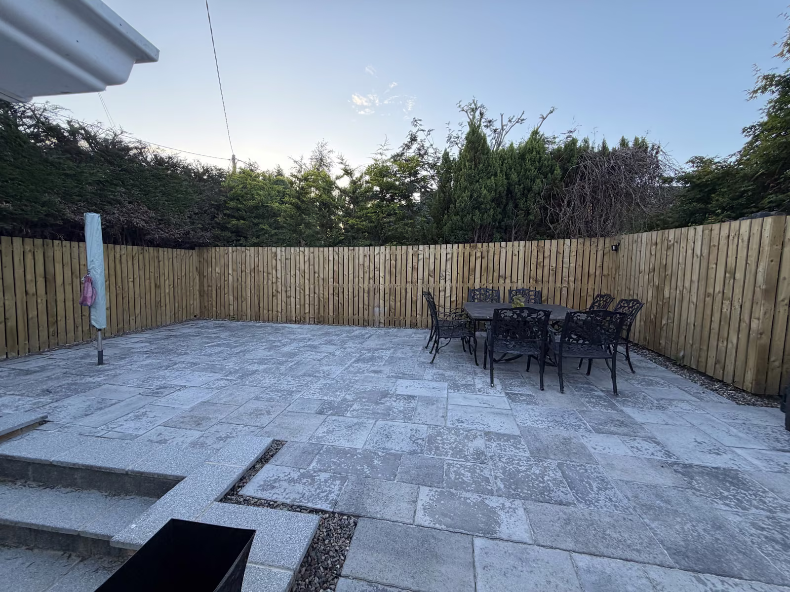 Private enclosed patio garden with paved terrace and outdoor furniture